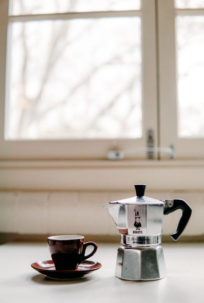 brown-cup-beside-a-coffee-maker