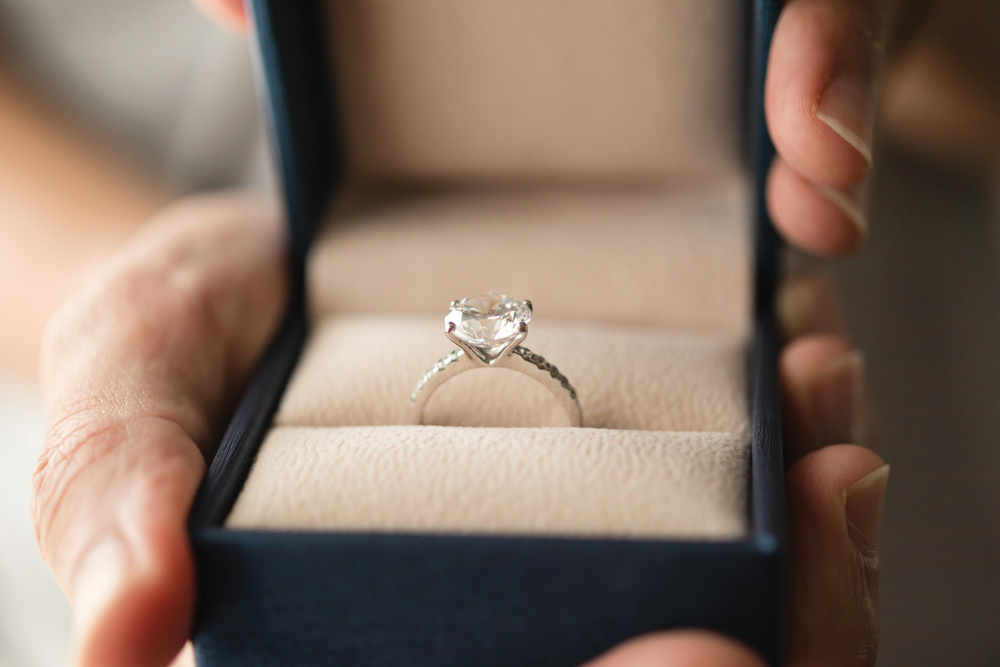 Hands holding diamond ring in jewelry box