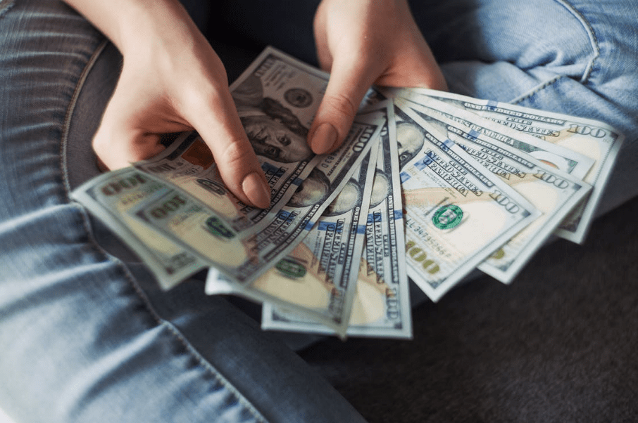 person-holding-100-us-dollar-banknotes