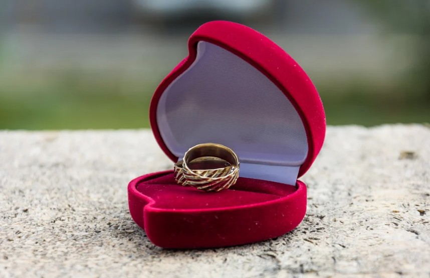 Gold rings in a red heart-shaped jewelry box