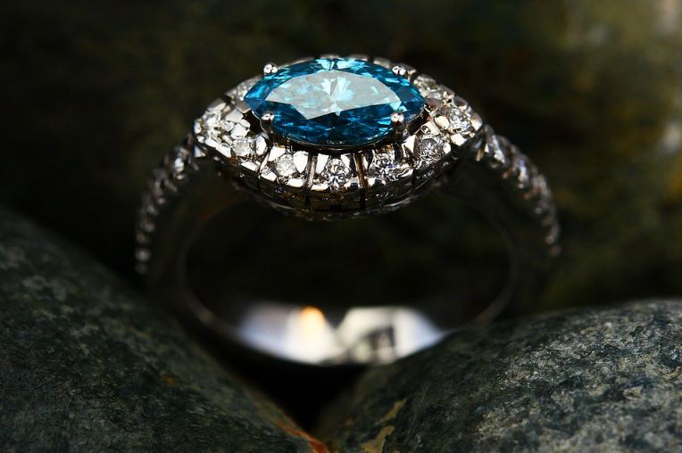 a ring with diamonds and a blue stone