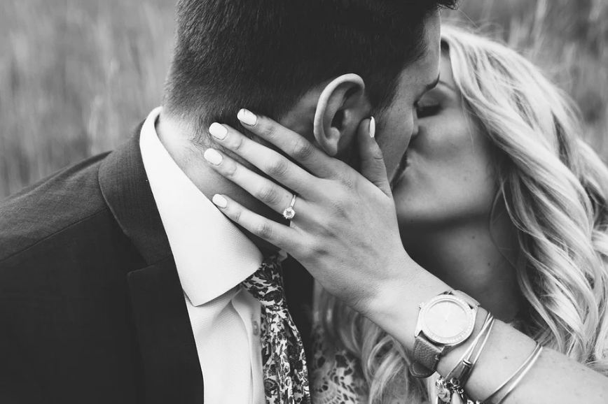 woman with engagement ring kissing her partner