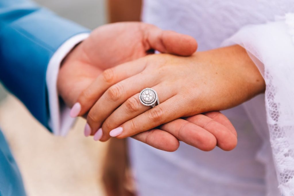 a groom holding the hand of his bride wearing a ring 