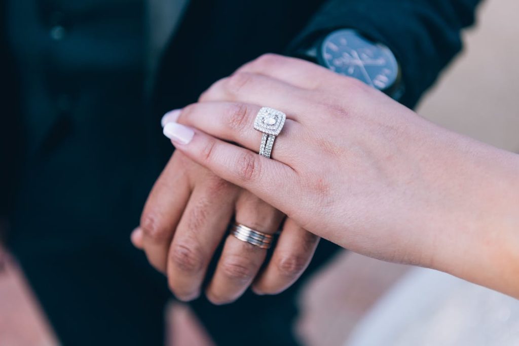 a picture of a bride's hand wearing a diamond-studded ring 