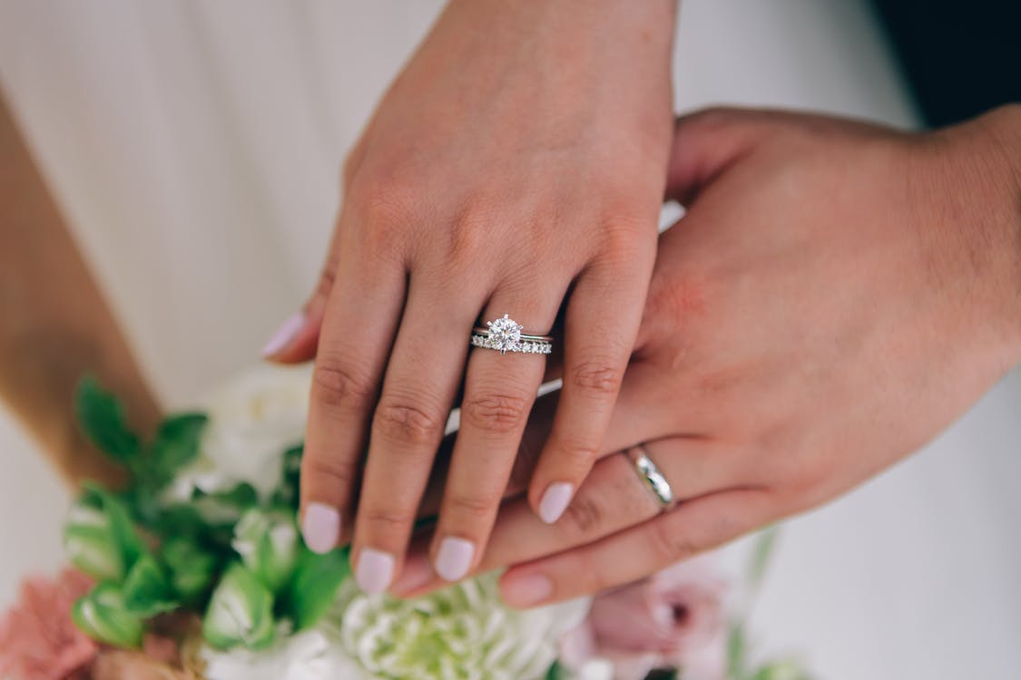 a picture of a couple wearing wedding rings