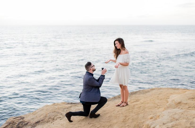 man proposing to a woman, beach, sand, sea