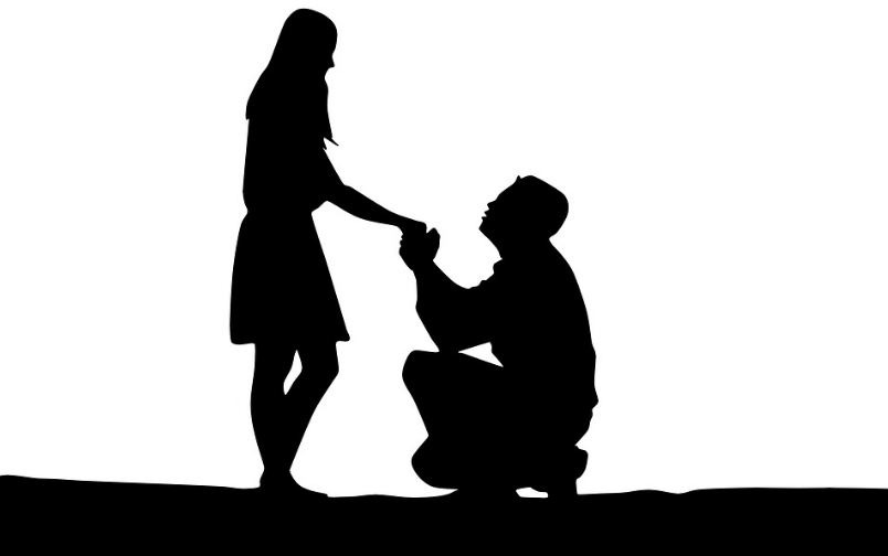 silhouette of a man proposing to a woman