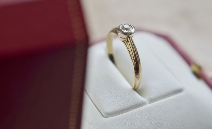 a gold engagement ring in a red box